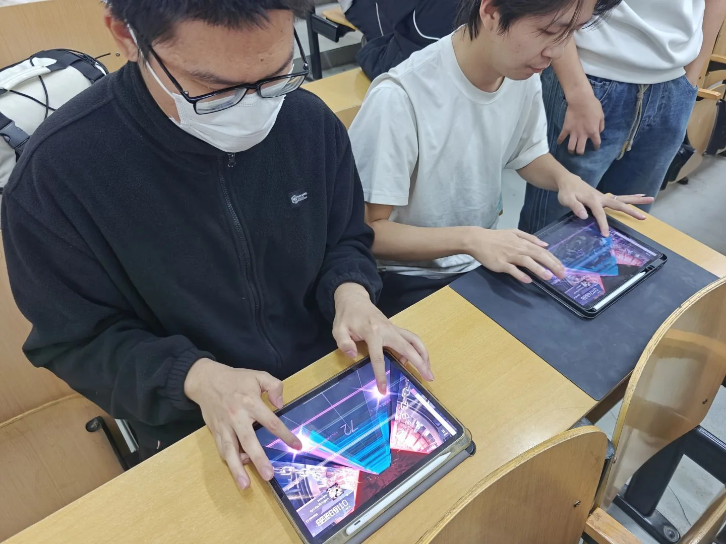 2025 冬音游大会现场，成员一起游玩移动端音游