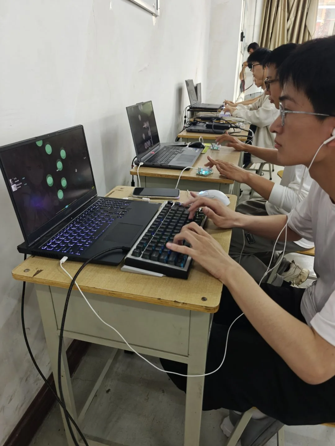 2026 夏音游大会现场，成员在笔记本上游玩 osu!